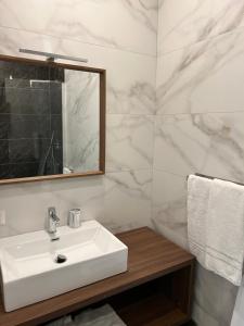 y baño con lavabo blanco y espejo. en Boutique Quartieri Spagnoli, en Nápoles