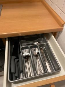 a drawer filled with utensils in a cabinet at Appartement Donauwelle 2 in Passau