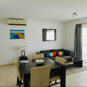 un soggiorno con tavolo e divano di Tranquil Apartment at Tortuga Beach - 221 a Prainha