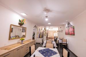 a dining room with tables and chairs and a mirror at Pousada Ma-juli in Olímpia