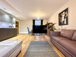 uma sala de estar com um sofá e uma televisão em Desirable 2 Bedroom Apartment in Bicester that sleeps 5 em Bicester