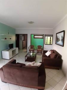 een woonkamer met 2 banken en een groene muur bij Apartamento inteiro( 1° andar) - Guarabira/PB in Guarabira