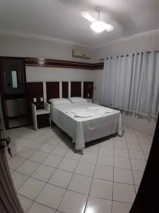een slaapkamer met een bed en een witte tegelvloer bij Apartamento inteiro( 1° andar) - Guarabira/PB in Guarabira