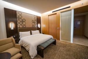 a bedroom with a bed and a couch and a chair at The Westin Kolkata Rajarhat in Kolkata