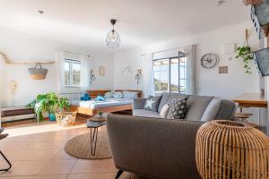 - un salon avec un canapé et un lit dans l'établissement Sweet Home Arrifana // Beachhouse, à Praia da Arrifana