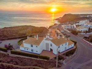 una vista aérea de una casa blanca con la puesta de sol en Sweet Home Arrifana // Beachhouse, en Praia da Arrifana