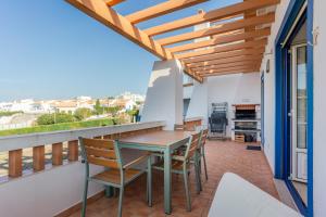patio con mesa y sillas en el balcón en Sweet Home Arrifana // Beachhouse, en Praia da Arrifana