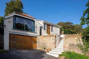 a house with a wooden door and a fence at The Tullet, boutique hideaway in Somerset in Banwell