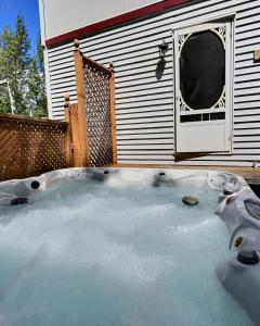 una bañera de hidromasaje frente a una casa en La Perchée Du Lac Miller, en Racine