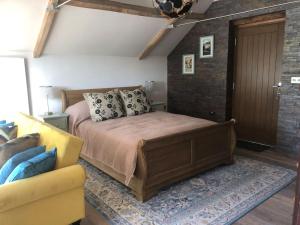 a bedroom with a bed and a couch at The Tullet, boutique hideaway in Somerset in Banwell