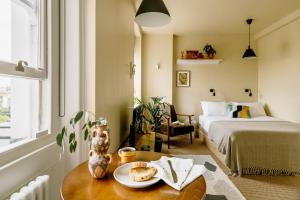 a room with a bed and a table with a plate of food at Mason & Fifth, Primrose Hill in London