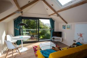 ein Wohnzimmer mit einem gelben Sofa und einem Tisch in der Unterkunft The Tullet, boutique hideaway in Somerset in Banwell
