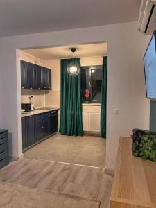 a kitchen with green curtains and a kitchen with a tub at Premium HILS Pallady in Bucharest