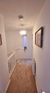 un pasillo vacío con una lámpara de araña en una casa en Penton place en Catterall