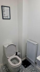 a white bathroom with a toilet and a radiator at Penton place in Catterall