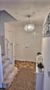 un pasillo con una lámpara de araña y una puerta blanca en Penton place en Catterall