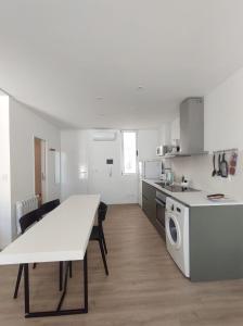 a kitchen with a white table and a table and a kitchen with a stove at HERMOSO DEPARTAMENTO EN EL CENTRO DE ROSARIO in Rosario