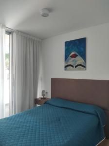 a bedroom with a blue bed and a window at HERMOSO DEPARTAMENTO EN EL CENTRO DE ROSARIO in Rosario
