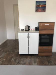 a kitchen with white cabinets and a microwave at Krakus in Kraków