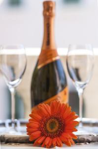 een fles wijn en een bloem naast twee wijnglazen bij Hotel Villa Serena in Marghera