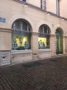 een gebouw met drie ramen met stoelen erin bij L'Apothicaire - BedinShop in Romans-sur-Isère