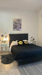 ein Schlafzimmer mit einem großen schwarzen Bett mit Kissen in der Unterkunft Casa Naranja habitaciones privadas in Cordoba