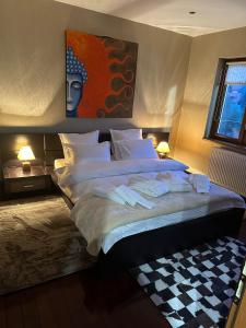 a bedroom with a large bed with white sheets and pillows at VILLA KYRA LUXURY in Sinaia