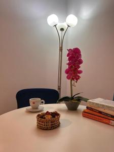 a table with a cup of coffee and a vase with a flower at Premium HILS Pallady in Bucharest