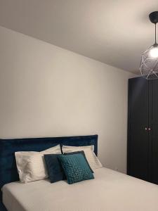 una camera con letto e testiera blu di Premium HILS Pallady a Bucarest