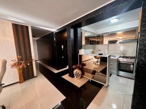 uma cozinha com electrodomésticos a preto e branco e uma mesa em Apartament zona fabricii Ford em Craiova