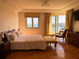 a bedroom with a bed and a large window at Liberty - Classic luxury sea view villa with private pool, Panoramic views to Kommeno & Corfu old Town in Kommeno