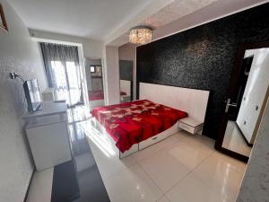 a bedroom with a bed with a red comforter at Apartament zona fabricii Ford in Craiova