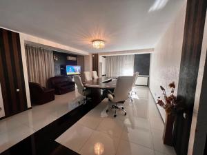 een woonkamer met een tafel, stoelen en een bank bij Apartament zona fabricii Ford in Craiova