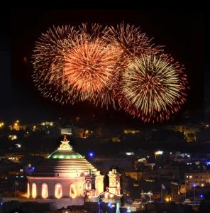 a firework display over a building with a building at Chic Penthouse industrial-style in Mosta