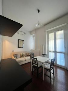 a living room with a table and chairs and a couch at Bocconi Apartment in Milan