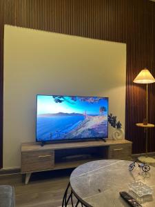 a living room with a flat screen tv on a entertainment center at Your first comfortable residence in Riyadh
