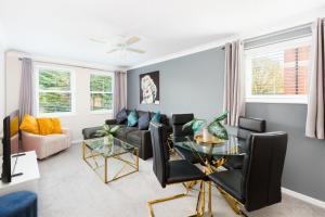 a living room with a black couch and a glass table at NEWLY RENOVATED, Chestnut Court, 2-Bedroom Apts, Private Parking, Fast Wi-Fi in Leamington Spa