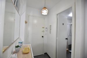 a bathroom with a white door and a table at Le Studio. Único, acogedor y en el centro de Vigo. in Vigo
