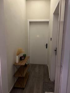 a hallway with a white door and a wooden table at Your first comfortable residence in Riyadh