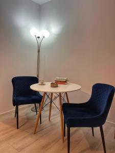 a table with two chairs and a table with a lamp at Premium HILS Pallady in Bucharest