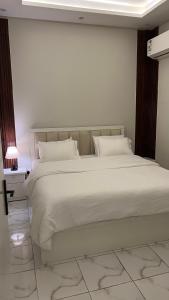 a bed with white sheets and pillows in a room at Your first comfortable residence in Riyadh