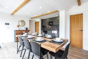 uma sala de jantar com uma grande mesa de madeira e cadeiras em The Coach House at Dovedale Manor em Tissington