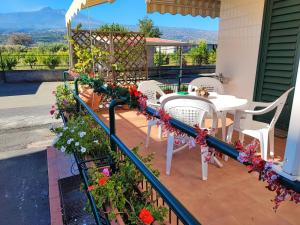 - un balcon avec une table, des chaises et des fleurs dans l'établissement Sea Garden, fronte mare con piscina, à Mascali