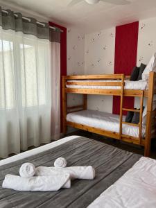 two bunk beds in a room with towels at Au Petit Bonheur in La Tranche-sur-Mer