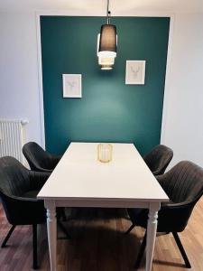 una mesa blanca y sillas en una habitación con una pared verde en Ferienwohnung in Freiberg nahe Bahnhof, en Freiberg