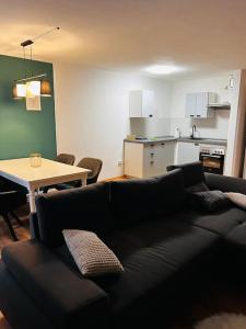 uma sala de estar com um sofá preto e uma cozinha em Ferienwohnung in Freiberg nahe Bahnhof em Freiberg
