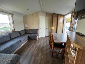 a living room with a couch and a table at Great 10 Berth Caravan At Martello Beach Holiday Park Ref 29045dw in Clacton-on-Sea