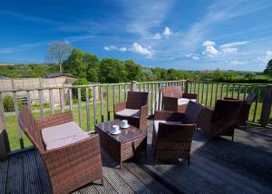 a group of chairs and a table on a deck at Meadow Lakes Holiday Park in St Austell