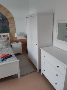 a bedroom with a bed and a white dresser at Tor zur Sächsischen Schweiz in Dohma