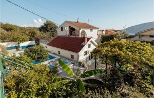 a white house with a red roof next to a pool at Beautiful Apartment In Herceg Novi With 1 Bedrooms, Wifi And Outdoor Swimming Pool in Herceg-Novi